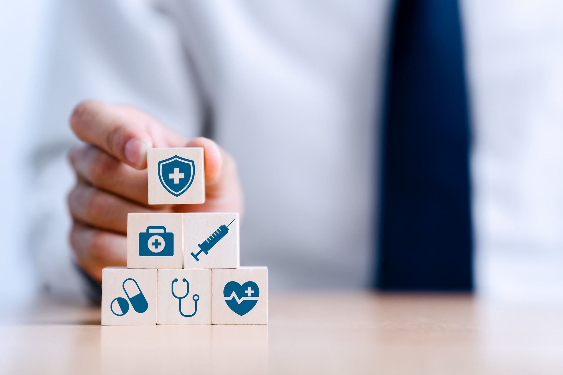 Hand arranging wood block stacking with the medical icon for healthcare and Health insurance management concept